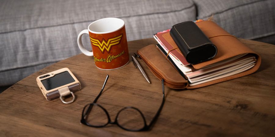 Image of a black woman sitting on the floor, with a laptop in front of her & notebook/journal on her lap as if on a coaching call. It gives the impression of someone working through their trauma and going on a journey of recovery, rediscovery and reconnection.